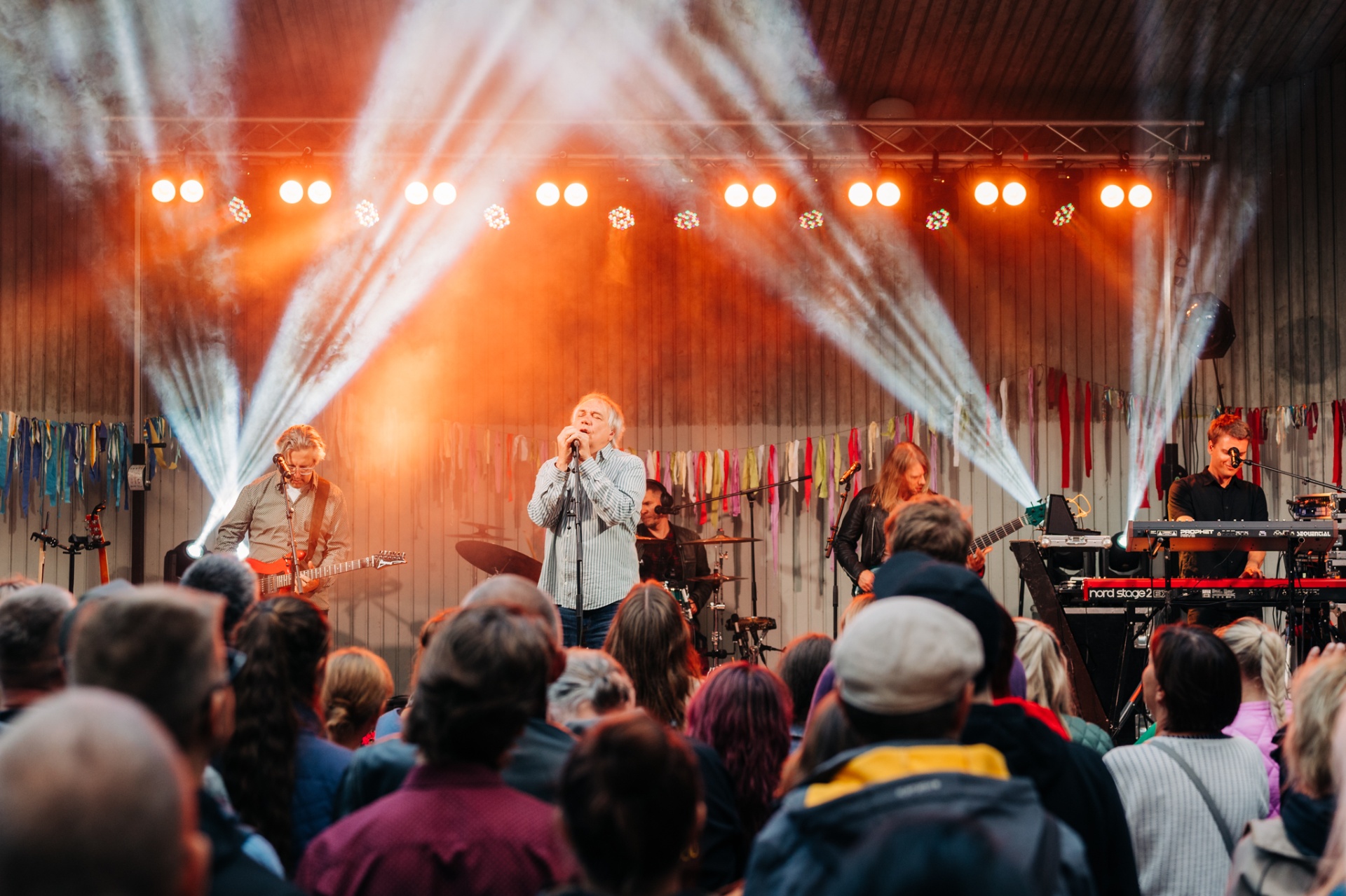 Külalised liiguvad metsa all lippude all festivalile